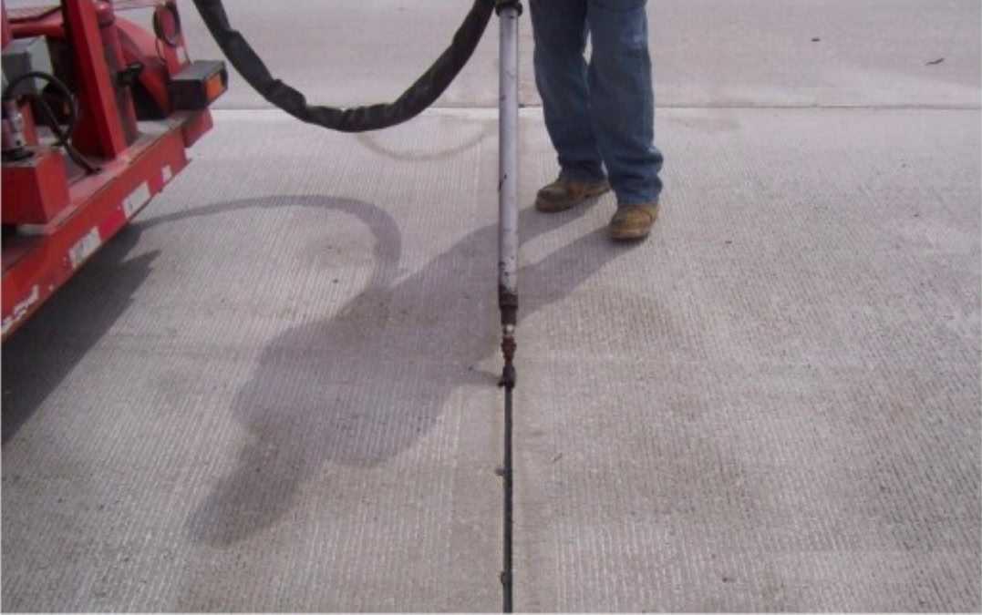 Worker with a sealant gun on a sidewalk