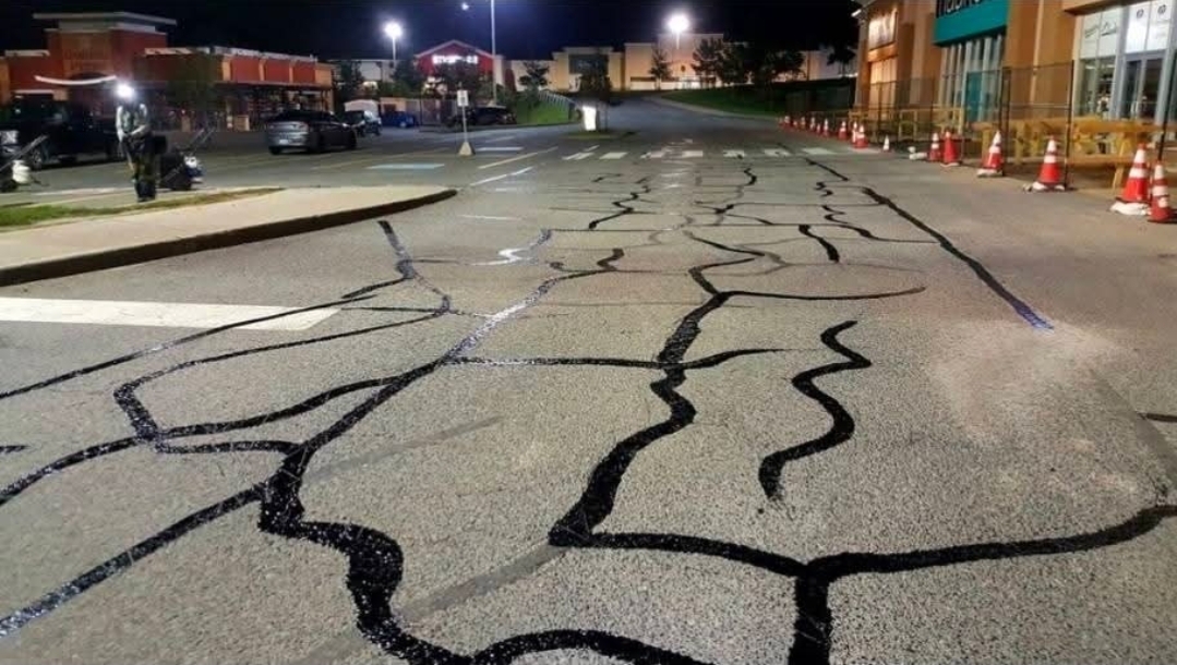 A close-up of a perfectly sealed asphalt crack.